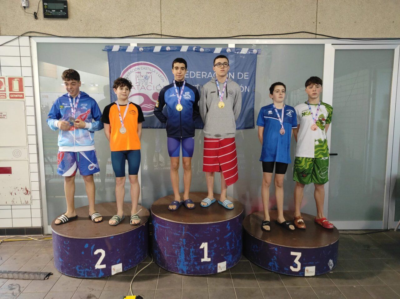 Nadadores en podio con medallas en campeonato de natación