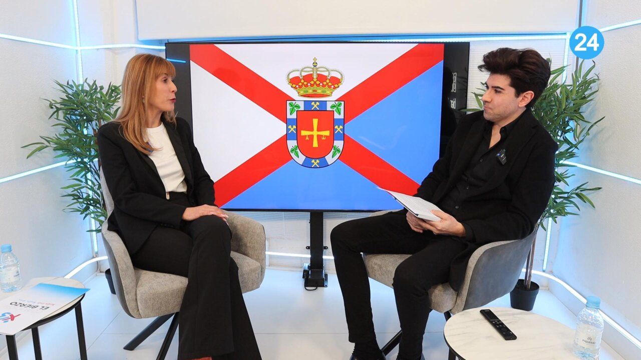 Myriam Blanco y un entrevistador discutiendo temas políticos en un set de televisión.