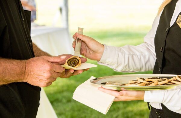 Camarero sirviendo aperitivos en un evento al aire libre
