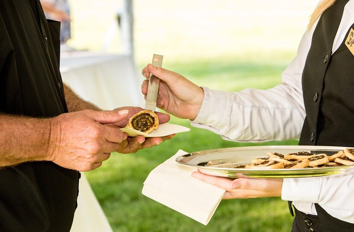 Camarero sirviendo aperitivos en un evento al aire libre