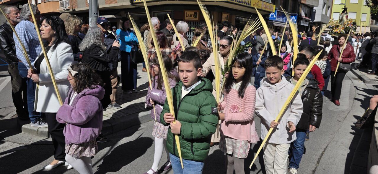 Niños y adultos en la procesión del Domingo de Ramos en Ponferrada