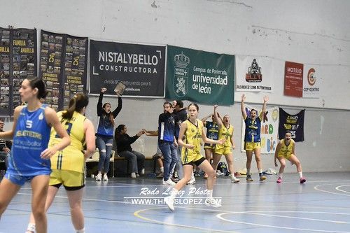 Jugadoras de baloncesto en un partido emocionante con defensas fuertes.