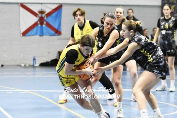 Jugadoras de baloncesto compitiendo por el balón en un partido