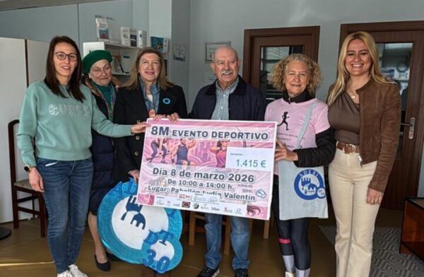Grupo de personas sosteniendo un cheque de recaudación solidaria del 8M