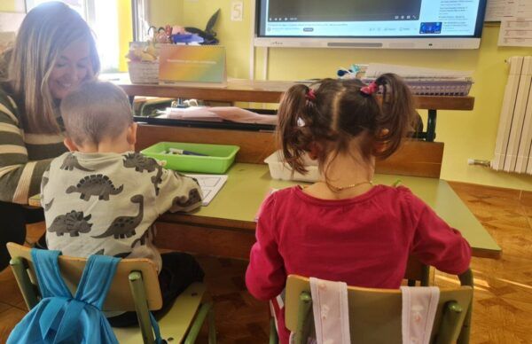 Niños en clase en la escuela de Canedo con una profesora