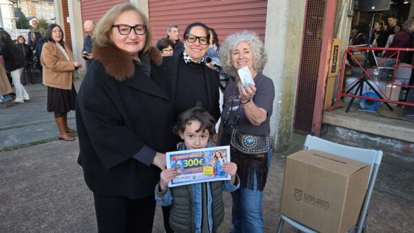 Grupo de personas en la feria de las rebajas sosteniendo un cheque regalo