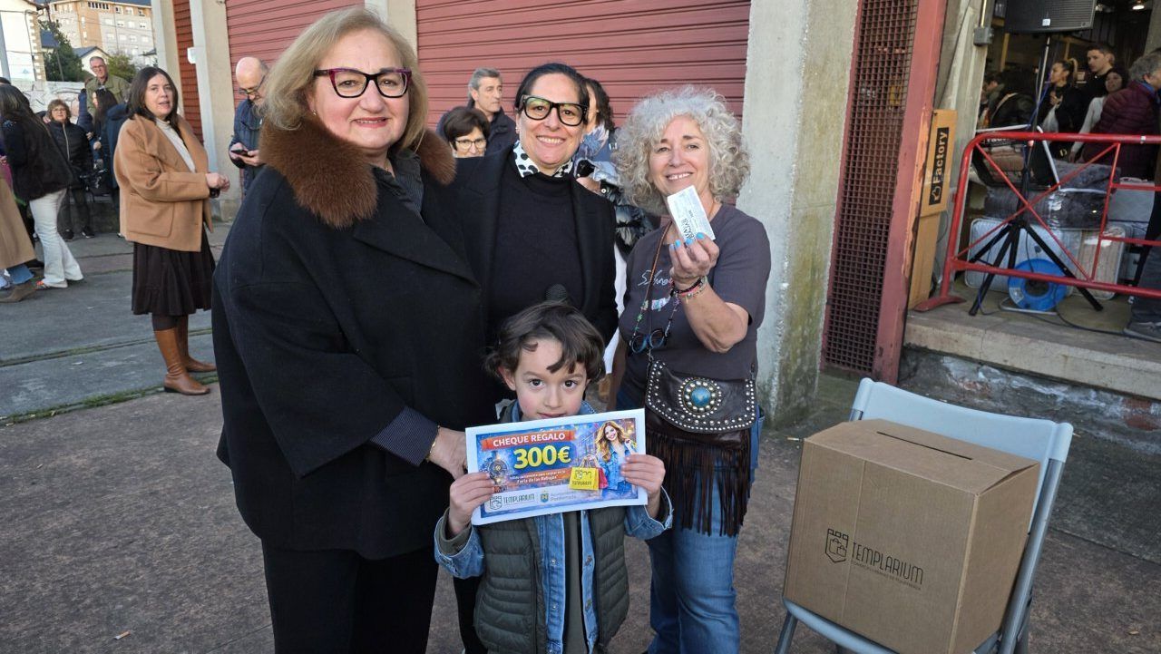 Grupo de personas en la feria de las rebajas sosteniendo un cheque regalo