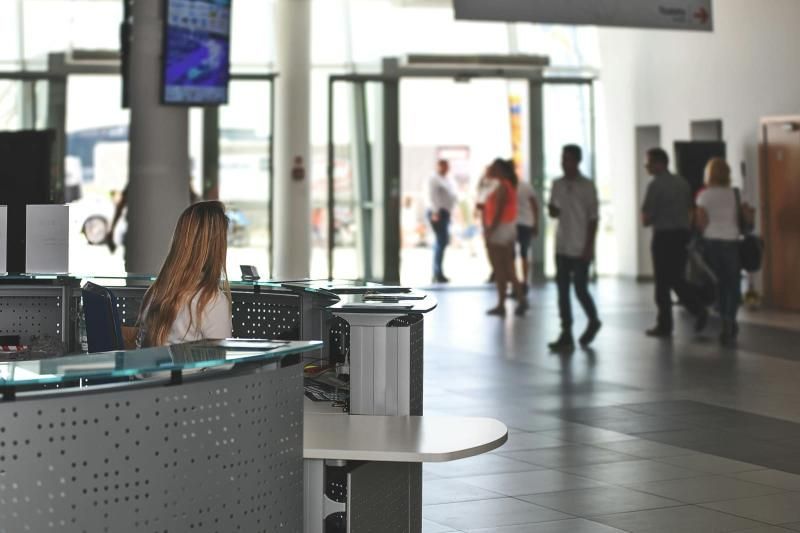Recepción en un edificio administrativo con personas entrando y saliendo.