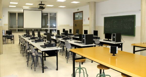 Aula de computación en el IES Gil y Carrasco con mesas y ordenadores