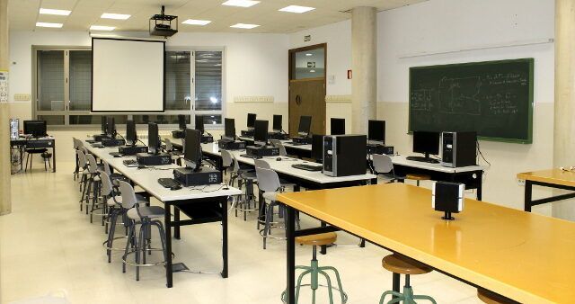 Aula de computación en el IES Gil y Carrasco con mesas y ordenadores