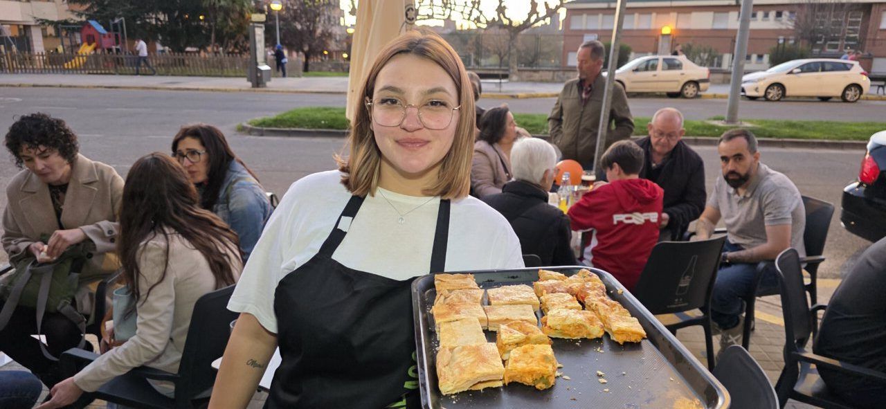 Mujer sonriente sosteniendo una bandeja con comida en el Bar Galapagos.