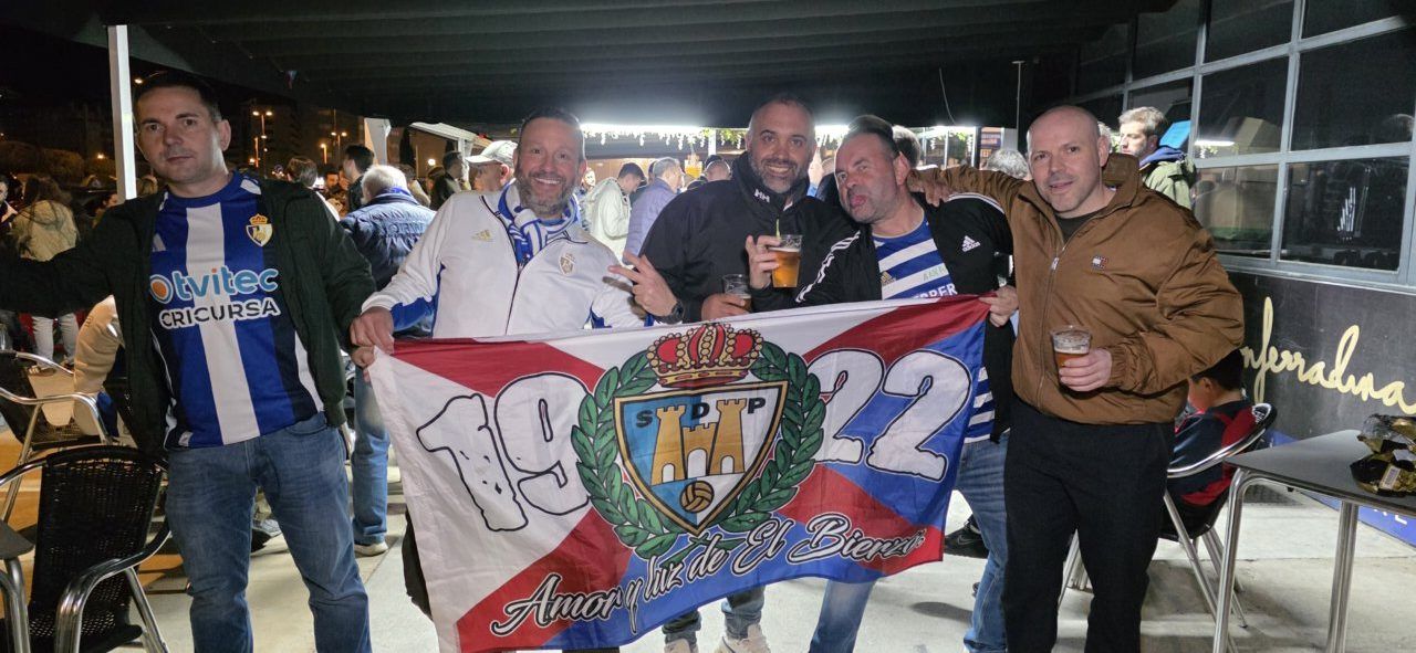 Grupo de aficionados de la Ponfe en el Bar El Toralín sosteniendo una bandera