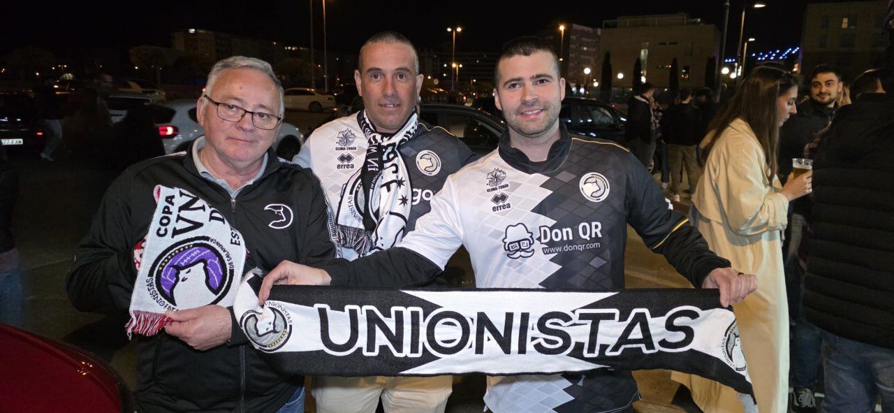 Tres aficionados de la Ponfe sosteniendo una bufanda de Unionistas