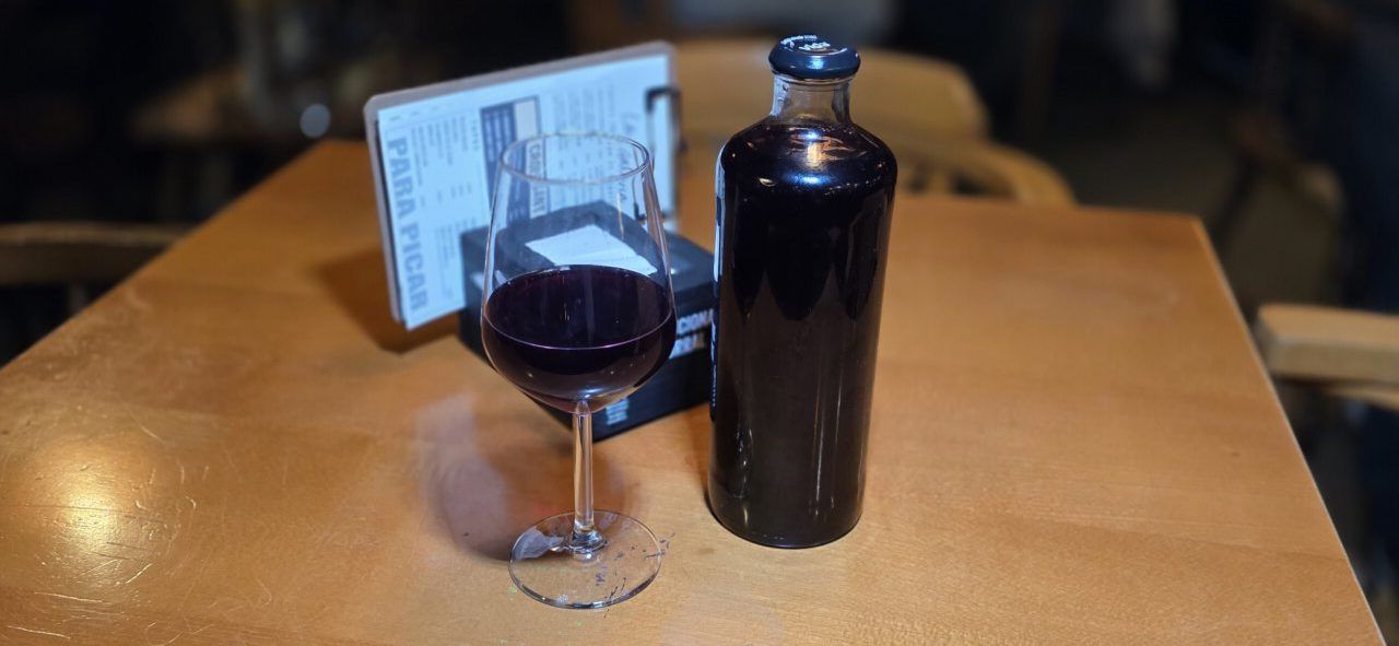 Vaso de limonada y botella en una mesa de bar