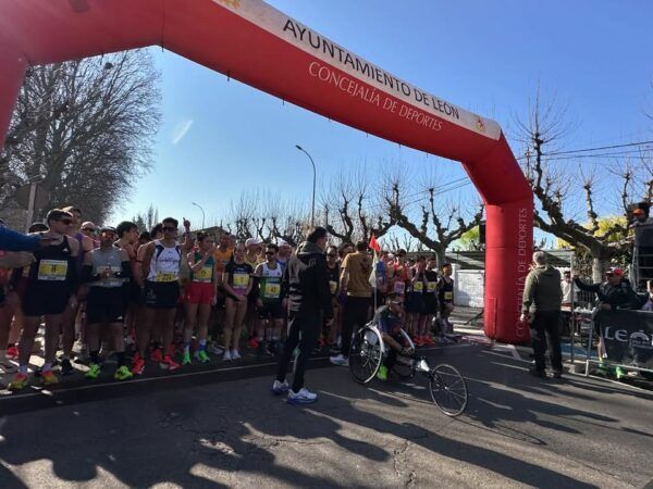 Corredores alineados en la salida de La Media de León bajo un arco de meta.