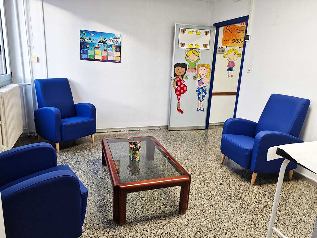 Sala de lactancia con sillones azules y decoración infantil
