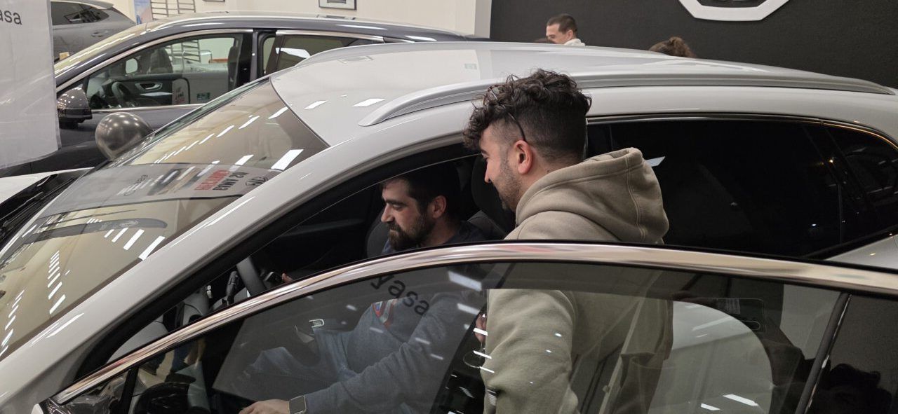 Dos hombres observan el interior de un coche MG S5 EV en Camponaraya.