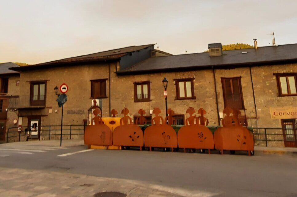 Mobiliario urbano en Villafranca del Bierzo con un arcoíris de fondo