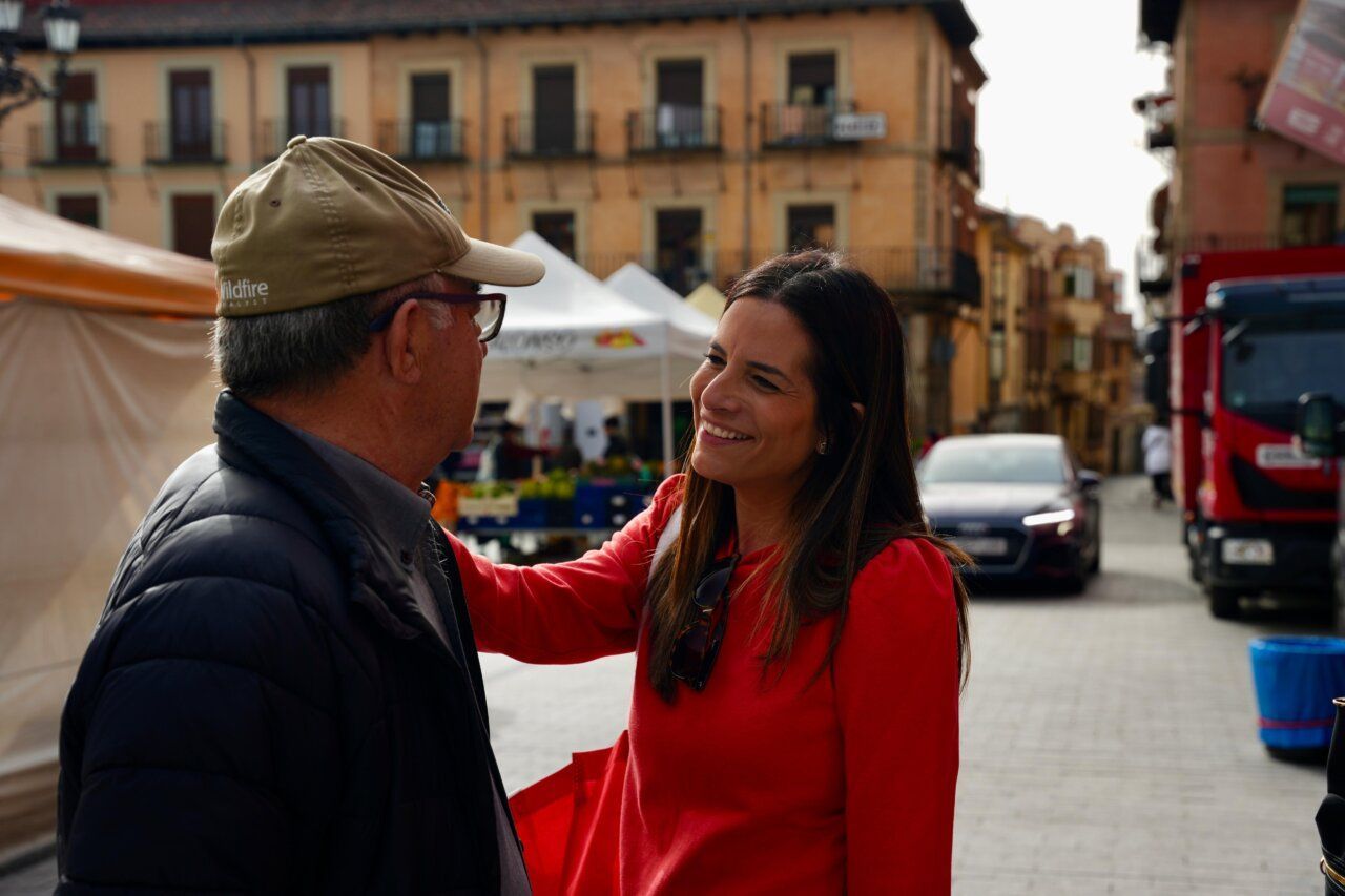 Nuria Rubio interactuando con un hombre en el mercado de León