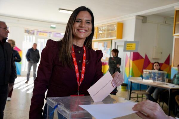 Mujer sonriendo mientras vota en una urna electoral