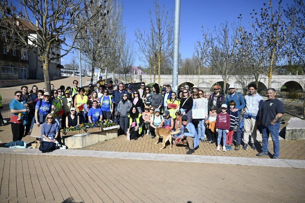 Grupo de personas plantando árboles autóctonos en la ribera del río Torío