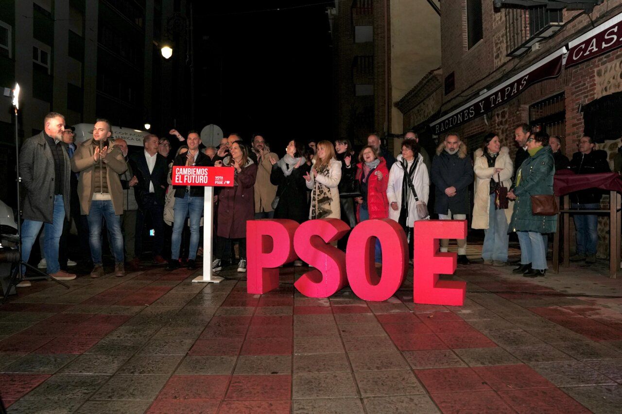 Evento del PSOE en León con participantes y cartel de campaña