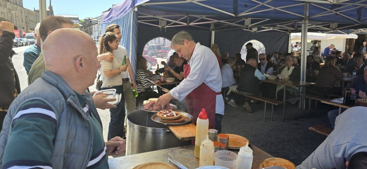 Personas disfrutando del pulpo en el mercadillo de Villafranca del Bierzo