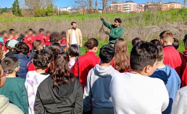 Escolares plantando robles autóctonos en un evento educativo