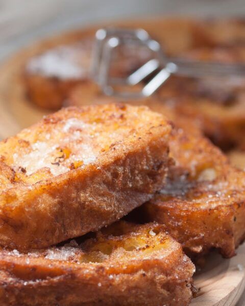 Torrijas doradas espolvoreadas con azúcar en un plato