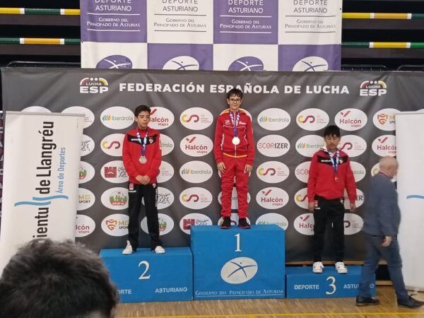 Joven luchador en podio tras ganar medalla de oro en campeonato