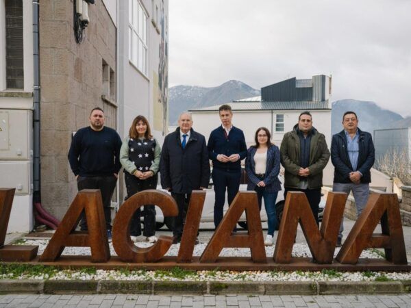 Grupo de personas en Villablino junto a un letrero de Laciana