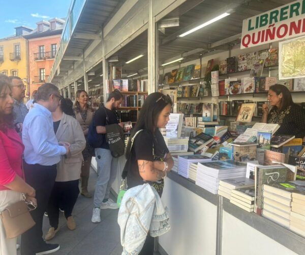Personas visitando la Feria del Libro en Ponferrada con libros expuestos.