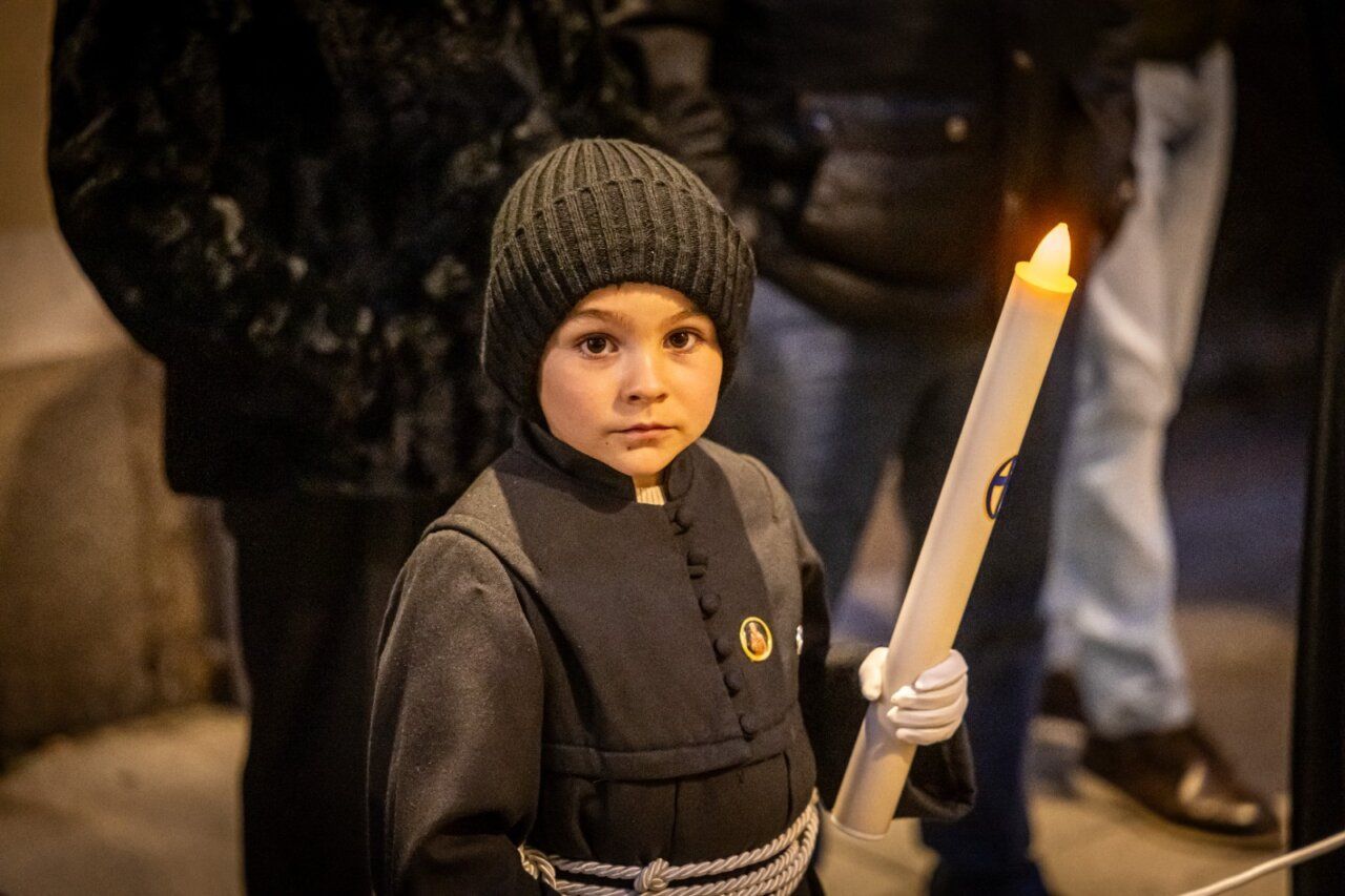 Niño sosteniendo una vela durante la Procesión del Silencio en La Bañeza
