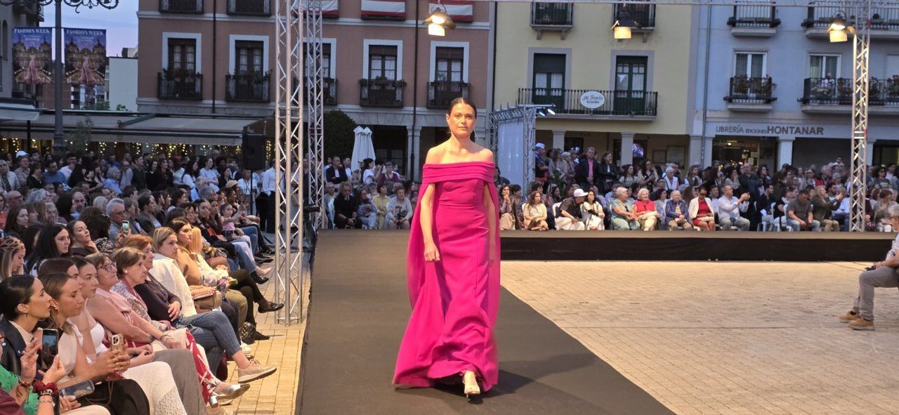 Modelo en pasarela con vestido rosa en desfile de moda