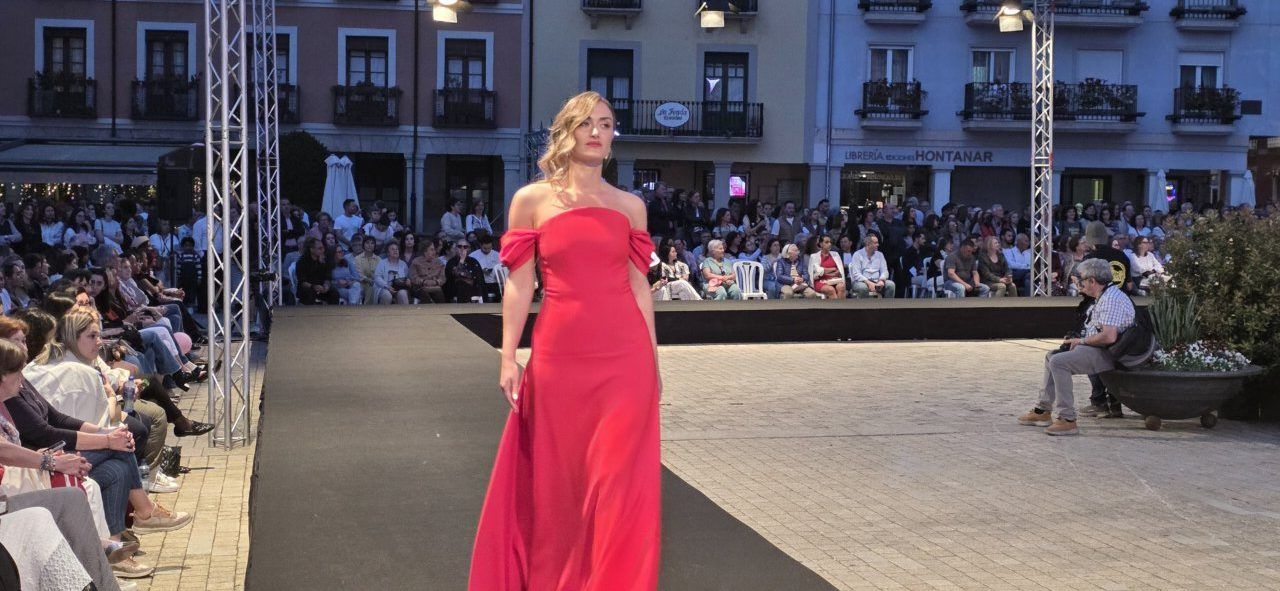 Modelo en un vestido rojo durante el desfile de moda en Ponferrada