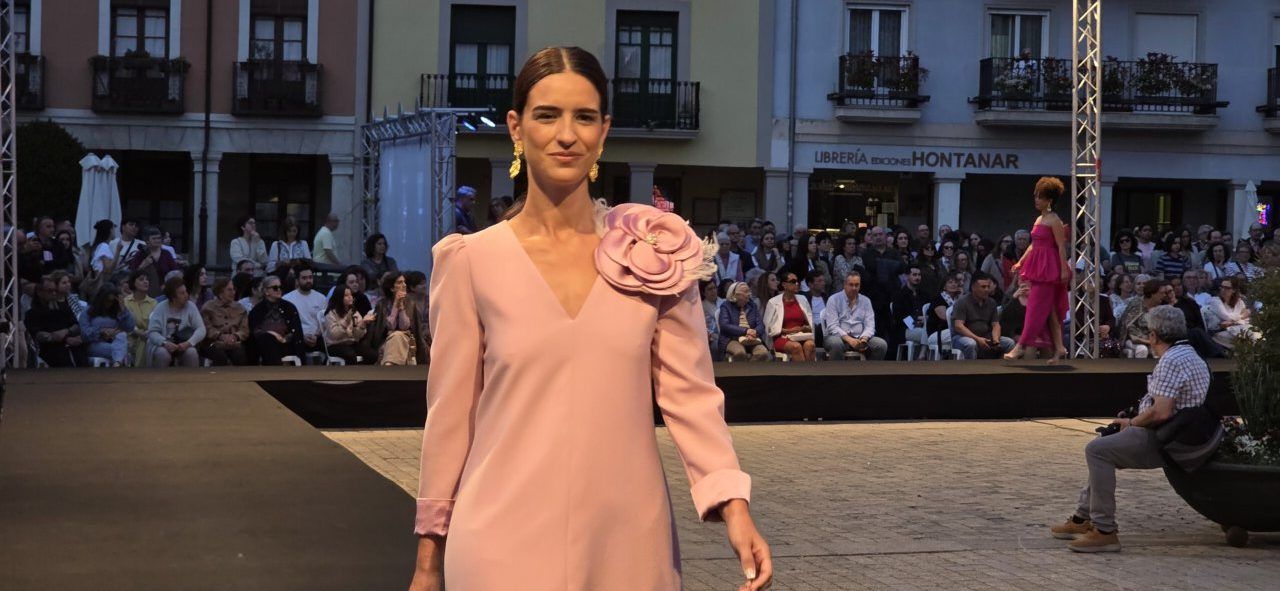 Modelo en vestido rosa con flor en el desfile de Silvia Fernández