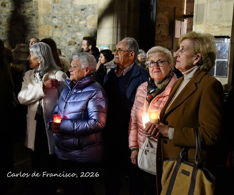 Vecinos de Cacabelos sosteniendo velas durante la Procesión del Santo Entierro