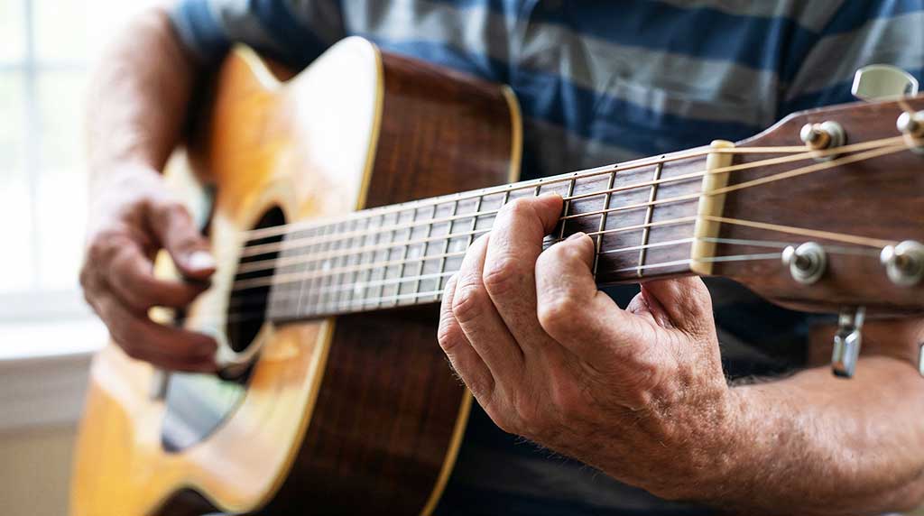Persona tocando la guitarra en una escuela de música
