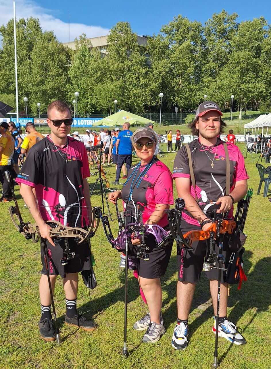 Tres arqueros bercianos posando con arcos en un evento de tiro con arco