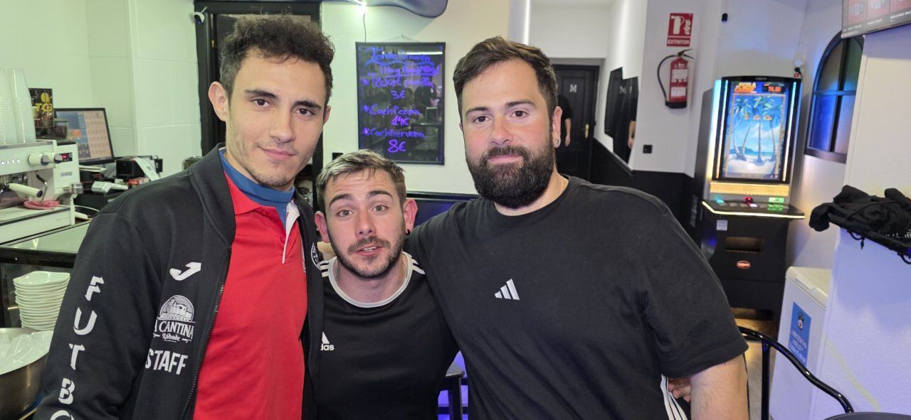 Tres hombres posando en el Bar Sueños tras un torneo de futbolín.