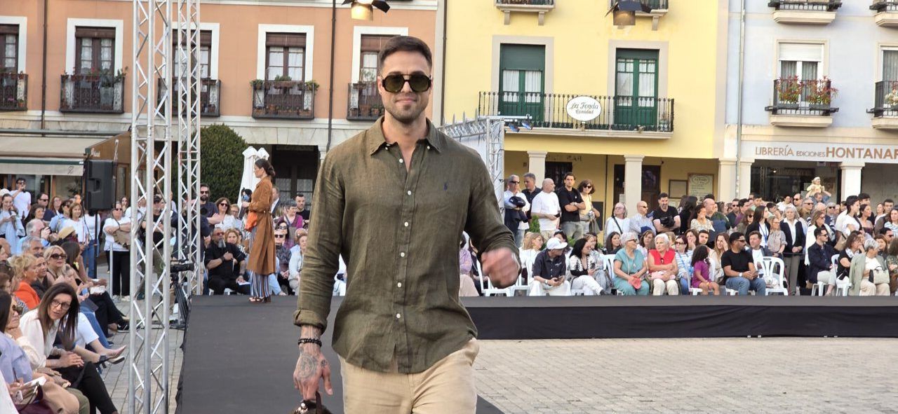 Modelo desfilando en evento de moda en Ponferrada con público atento.