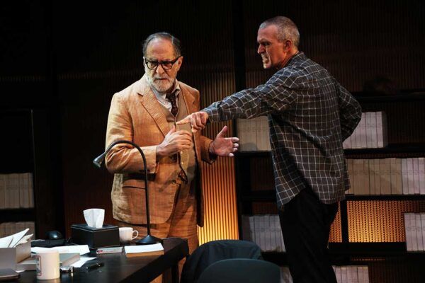 Escena de la obra El dilema del corcho con dos actores en un despacho.