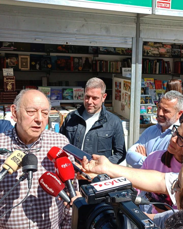 Persona hablando en la Feria del Libro Antiguo en Ponferrada con libros de fondo