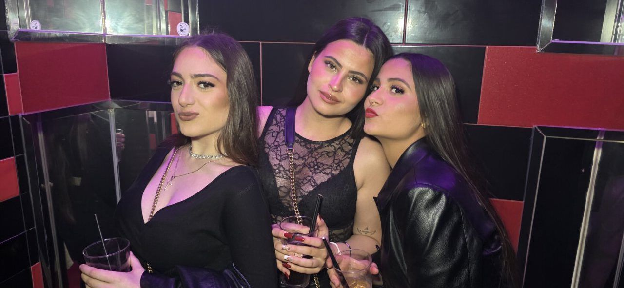 Tres mujeres posando en un bar durante la fiesta de Jueves Santo