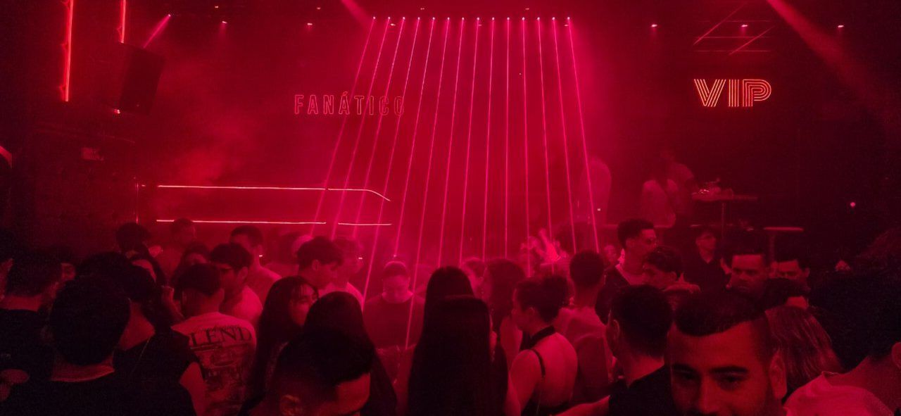 Fiesta de Jueves Santo en Ponferrada con luces rojas y gente bailando