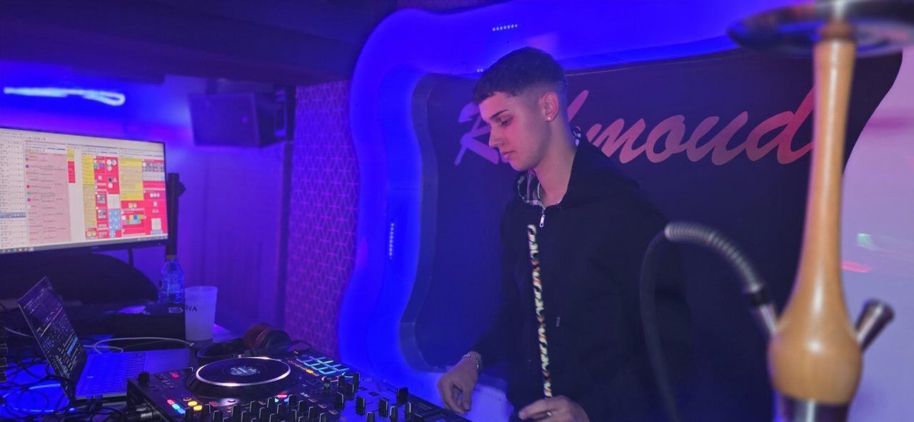 DJ actuando en un evento nocturno con luces de colores