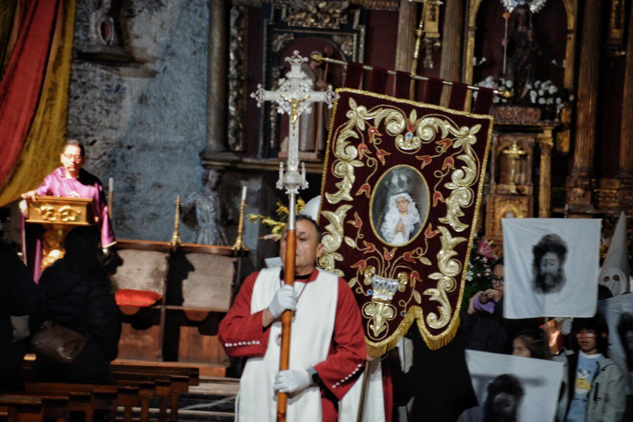 Participante sosteniendo un estandarte en la procesión de la Pasión