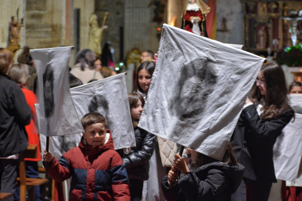 Niños sosteniendo banderas en la procesión de la Pasión en Carracedo del Monasterio