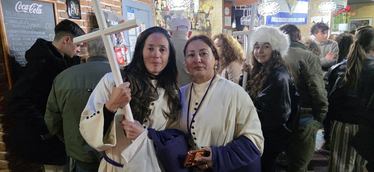 Dos mujeres sosteniendo un palo en un bar durante la Semana Santa