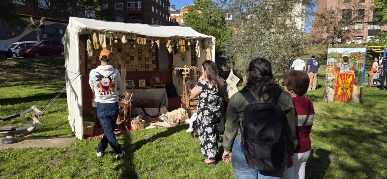 Visitantes en un mercado romano en Ponferrada con un puesto de artesanías